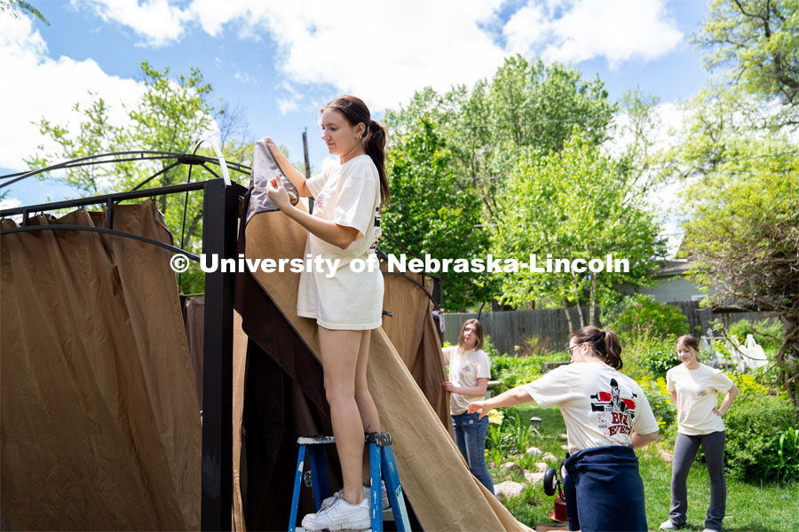 Alyssa Dunlap of Tri Delta attaches the outer curtain of a pergola during the Big Event. May 4, 2024. Photo by Kirk Rangel for University Communication.